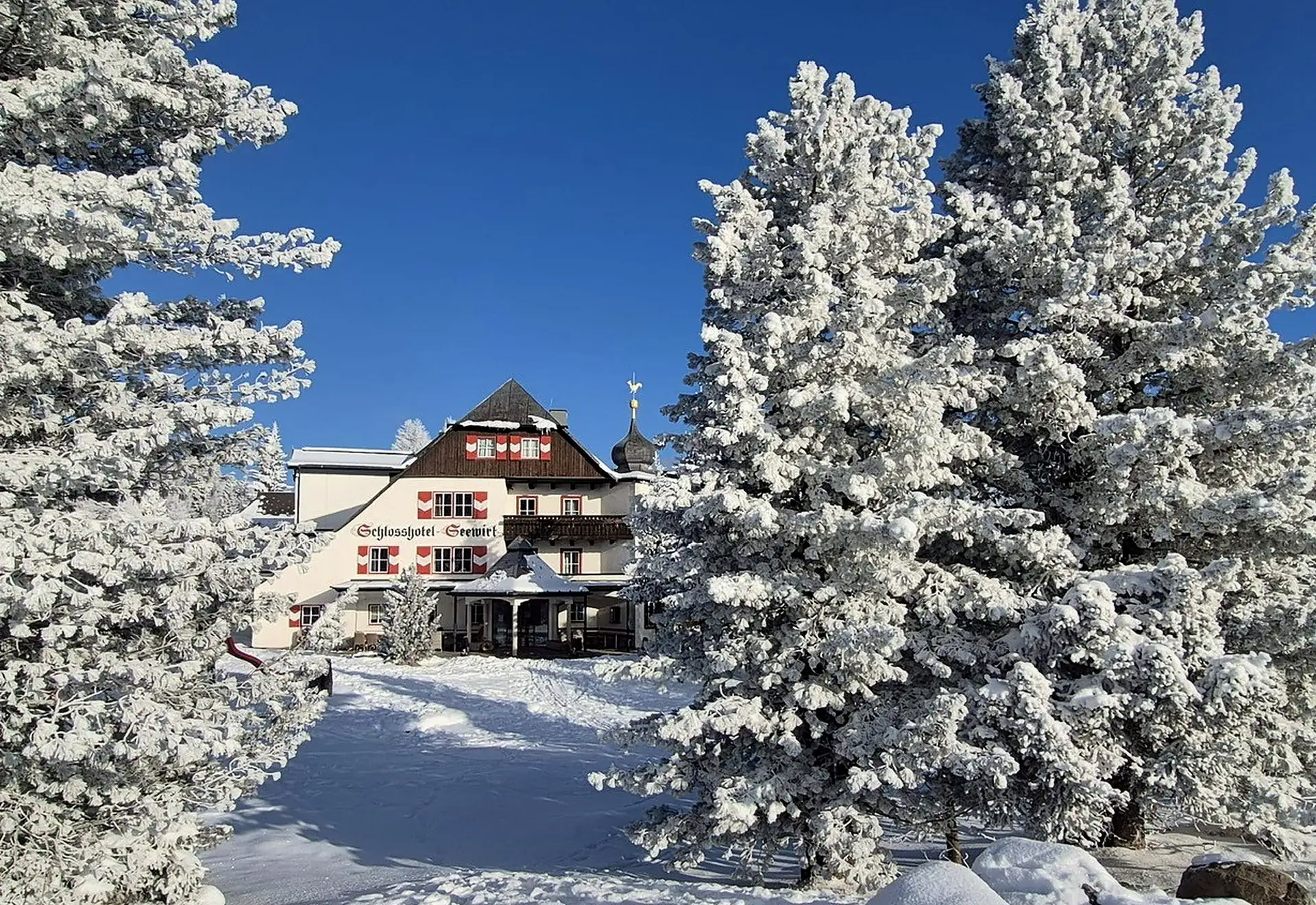Schlosshotel Seewirt mezi ojíněnými limbami za soumraku